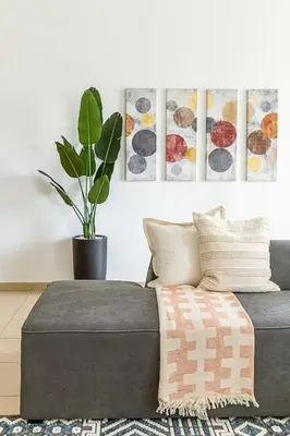a couch in a living room with a potted plant at Frank Porter - Bahar 1 in Dubai