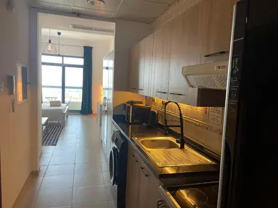 a kitchen with a sink and a stove top oven at Studio in Silicon Oasis in Dubai
