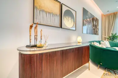 a living room with a table and a green couch at Picturesque 3BR with Assistant Room at The One JBR by Deluxe Holiday Homes in Dubai