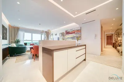 a kitchen with a counter and a living room at Picturesque 3BR with Assistant Room at The One JBR by Deluxe Holiday Homes in Dubai