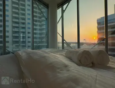 a bed with a towel on it in a room with windows at Lxry Full Marina View & RoofTop Pool 40% OFF in Dubai