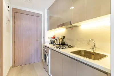 a kitchen with a sink and a washing machine at Modern Stu Near Downtown Dubai Pool Gym WiFi in Dubai