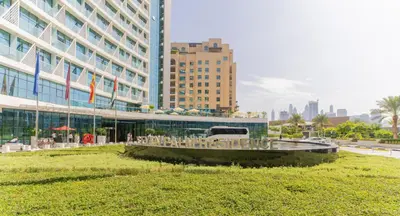 a large building with a fountain in front of it at Studio with private beach access at Palm Jumeirah in Dubai