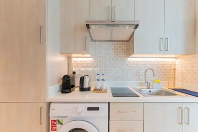 a kitchen with a washing machine and a sink at Studio with private beach access at Palm Jumeirah in Dubai