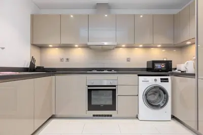 a kitchen with a washing machine and a microwave at Spacious Minimalistic Studio in Dubai