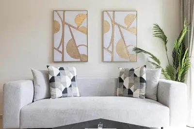 a living room with a couch and two pictures on the wall at HomesGetaway -Lavish 1BR in ACT One Downtown Dubai in Dubai