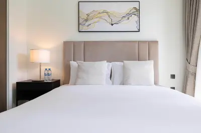 a bedroom with a large white bed and a lamp at HomesGetaway -Lavish 1BR in ACT One Downtown Dubai in Dubai
