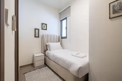 a small bedroom with a bed and a mirror at Exclusive Spacious Villa I Garden I Maid Room in Dubai