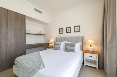 a bedroom with a white bed and two lamps at Exclusive Spacious Villa I Garden I Tilal Al Ghaf in Dubai