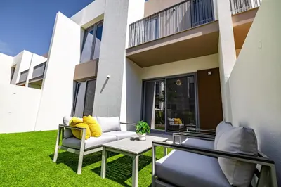 a patio with a couch and a table in front of a house at Exclusive Spacious Villa I Garden I Tilal Al Ghaf in Dubai