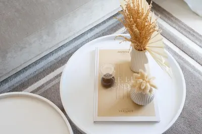 a white table with a book and flowers on it at Keyrock Living - Lakeview Escape in Business Bay in Dubai