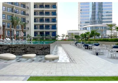 a patio with tables and chairs and a building at Keyrock Living - Lakeview Escape in Business Bay in Dubai