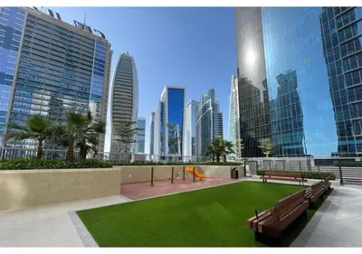 a park with benches and grass in a city at Keyrock Living - Lakeview Escape in Business Bay in Dubai