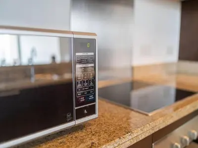 a microwave oven sitting on a counter in a kitchen at Elegant Apartment Overlooking Dubai Mall Fountain. in Dubai