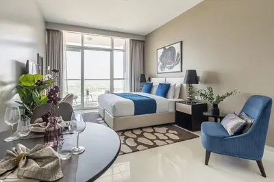 a hotel room with a bed and a table and a dining room at Frank Porter - DAMAC Artesia in Dubai