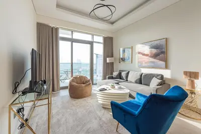 a living room with a couch and a tv at Modern 1BR at Farhad Azizi Al Jaddaf - Sleeps 4 in Dubai