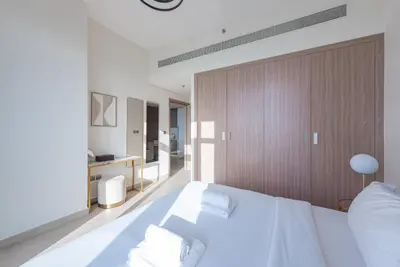 a bedroom with a white bed and a bathroom at Modern 1BR at Farhad Azizi Al Jaddaf - Sleeps 4 in Dubai