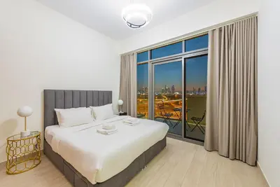 a bedroom with a bed and a large window at Modern 1BR at Farhad Azizi Al Jaddaf - Sleeps 4 in Dubai