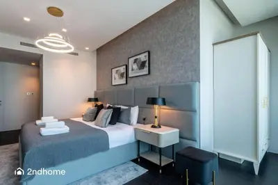 a bedroom with a bed and a desk with a lamp at Seaside Splendor The Palm's Breathtaking View in Dubai