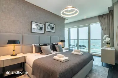 a bedroom with a bed with two towels on it at Seaside Splendor The Palm's Breathtaking View in Dubai
