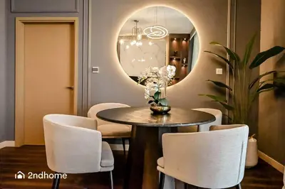 a dining room with a table and chairs and a mirror at Luxurious 1 Bed with Direct Access to Dubai Mall in Dubai