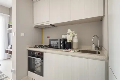 a kitchen with white cabinets and a sink at Frank Porter - Zada Tower in Dubai