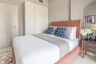 a bedroom with a white bed with blue pillows at Frank Porter - Zada Tower in Dubai