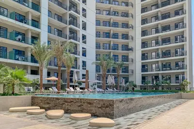 a swimming pool in front of a large building at Frank Porter - Zada Tower in Dubai