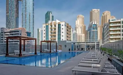 a swimming pool with lounge chairs and a city skyline at Studio With Best View Of Dubai in Dubai