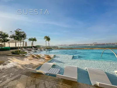 a swimming pool with lounge chairs in a resort at Emaar Beachfront - Beach Vista Tower, Dubai Marina in Dubai