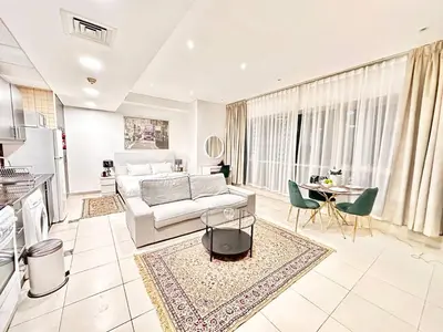 a living room with a white couch and a table at Lovely Newly Furnished Ocean View Studio in Royal Oceanic Tower in Dubai