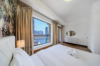 a bedroom with a white bed and a large window at Jumeirah Beach Residence - Bahar 6, Dubai Marina in Dubai