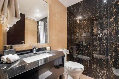 a bathroom with a sink and a toilet and a mirror at Daniels Cityscape Studio at Elite Downtown in Dubai