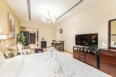 a large bedroom with a large bed and a living room at Daniels Cityscape Studio at Elite Downtown in Dubai