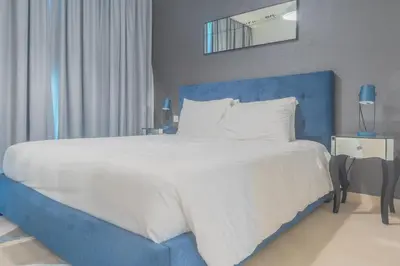 a large bed with a blue headboard and white sheets at BellaVista Downtown Views II T1 - 2 bedroom apartment with Burj Khalifa View in Dubai