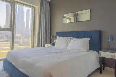 a large bed in a hotel room with a large window at BellaVista Downtown Views II T1 - 2 bedroom apartment with Burj Khalifa View in Dubai