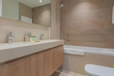 a bathroom with a sink and a tub and a toilet at BellaVista Downtown Views II T1 - 2 bedroom apartment with Burj Khalifa View in Dubai