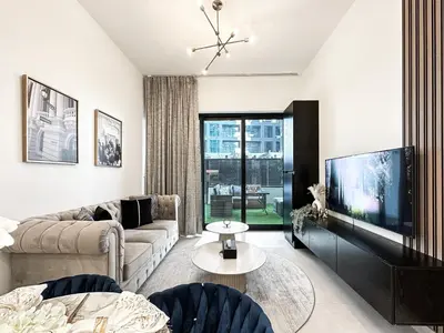 a living room with a couch and a tv at Trophy Lux Suite With Garden Balcony and Burj Khalifa Views in Dubai
