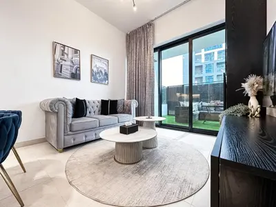 a living room with a couch and a table at Trophy Lux Suite With Garden Balcony and Burj Khalifa Views in Dubai