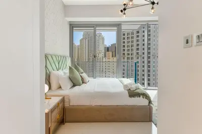 a bedroom with a bed and a large window at Newly Designed 3 beds w marina eye view in Dubai