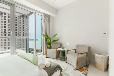 a bedroom with a bed and a large window at Newly Designed 3 beds w marina eye view in Dubai