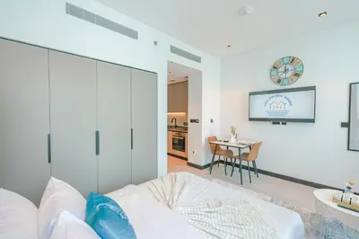 a white room with a bed and a table at Urban Skyline City Comfort Studio in Dubai