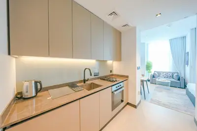 a kitchen with white cabinets and a counter top at Urban Skyline City Comfort Studio in Dubai