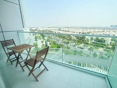 a balcony with two chairs and a table on it at Modern Condo With Wide City Views From Balcony in Dubai