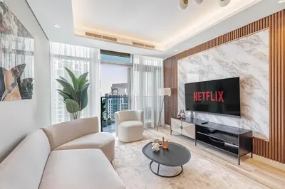 a living room with a couch and a television at Daniels Burj Khalifa View 2BR at Paramount Midtown in Dubai