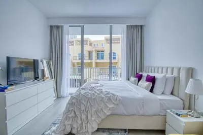 a bedroom with a large bed and a television at The Smart Concierge - Luma 21 in Dubai