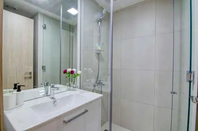 a bathroom with a shower and a sink and a mirror at The Smart Concierge - Luma 21 in Dubai
