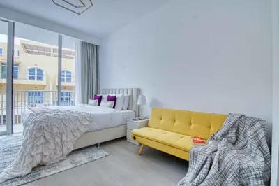 a bedroom with a yellow bed and a yellow couch at The Smart Concierge - Luma 21 in Dubai