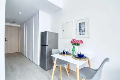 a kitchen with a white table and a refrigerator at The Smart Concierge - Luma 21 in Dubai