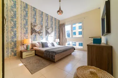 a bedroom with a bed and a large window at 1BR Spacious Apartment in Marina Sail By PK Holidays in Dubai